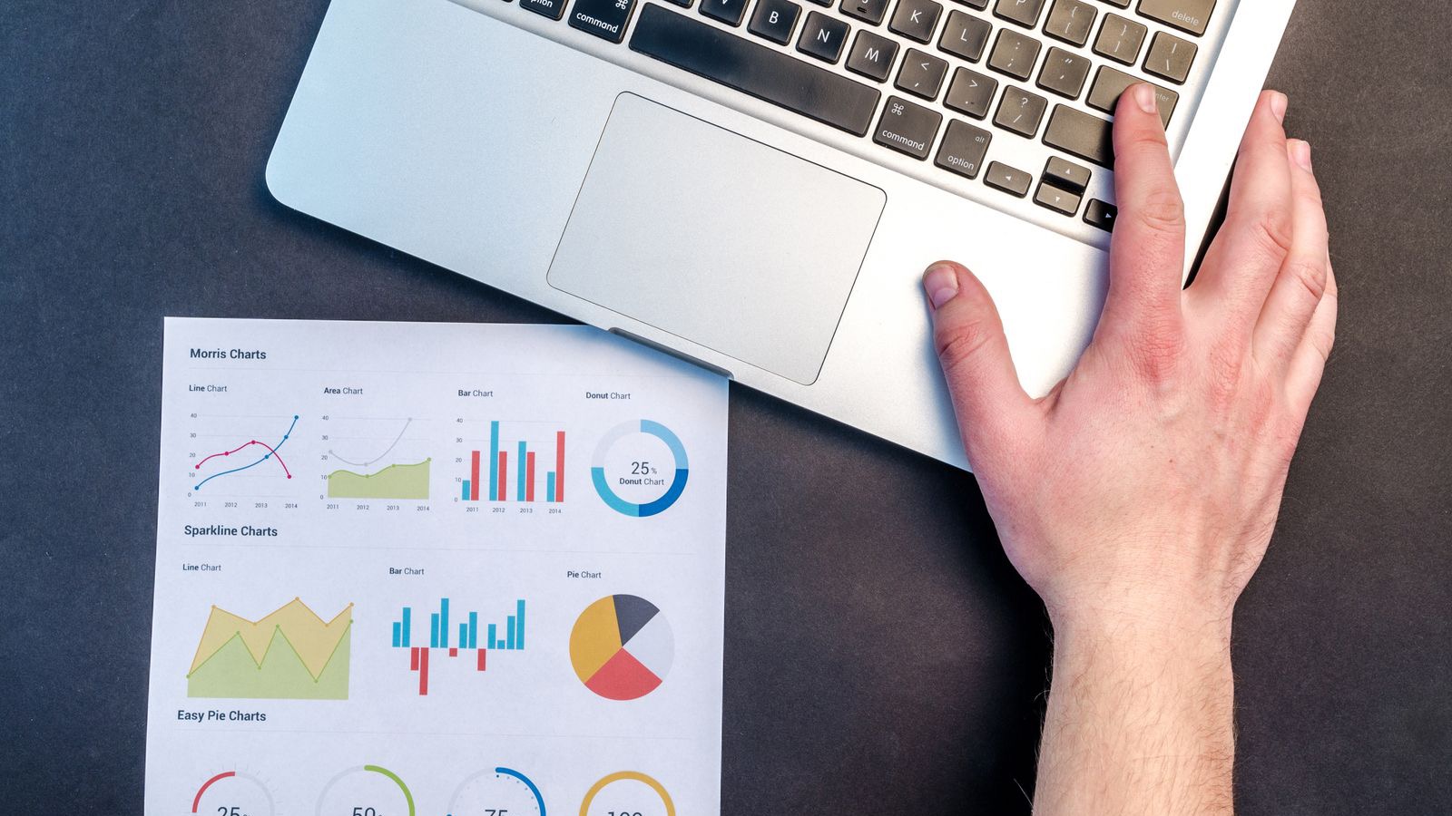 Laptop and printed charts during a cost analysis: make-or-buy calculation for installation services