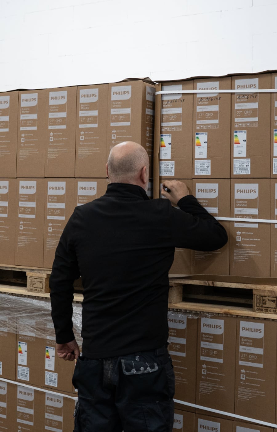 FASTNET-Techniker in neutraler Arbeitskleidung bei Smartboard-Wandmontage